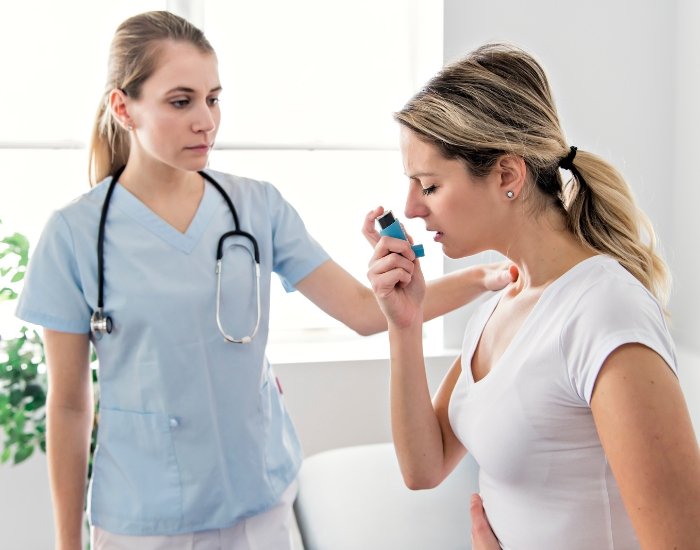 Clinician showing a woman how to use an asthma inhaler Clinician showing a woman how to use an asthma inhaler