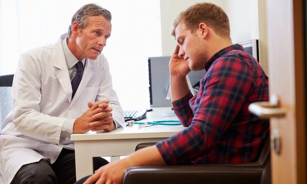 Middle-aged man sitting alone showing symptoms of depression associated with low testosterone
